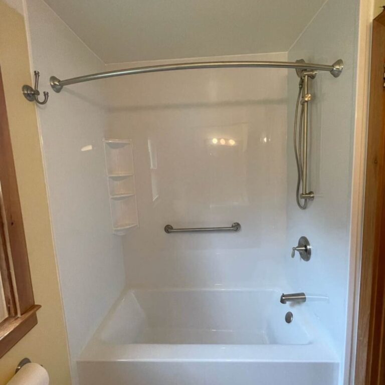 New white tub and wall surround complete with brushed nickel fixtures and accessories