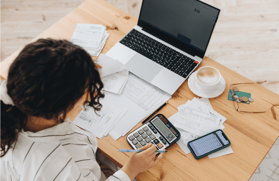 women at computer with calculator budgeting.
